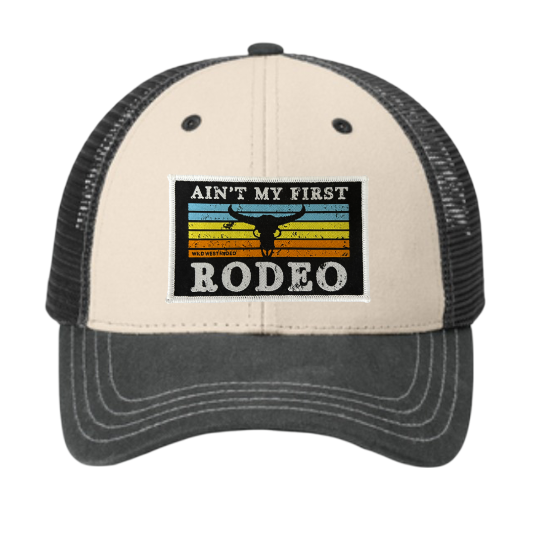 Trucker hat with 'Ain't My First Rodeo' text and graphic on a white background