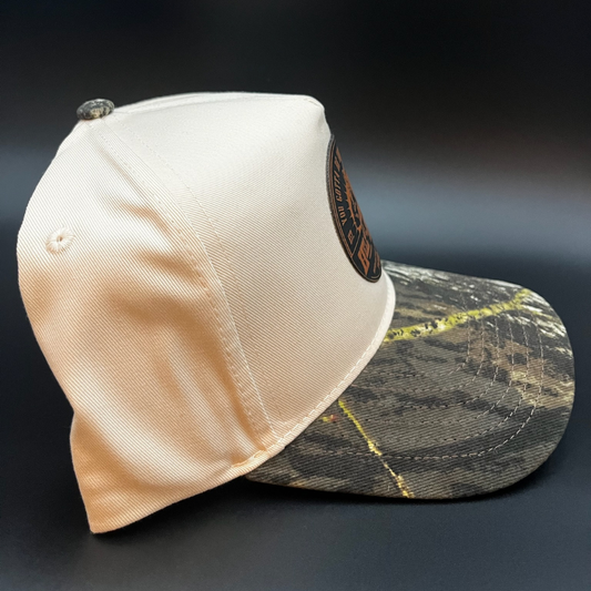 Beige cap with a camouflage pattern on the brim against a dark background